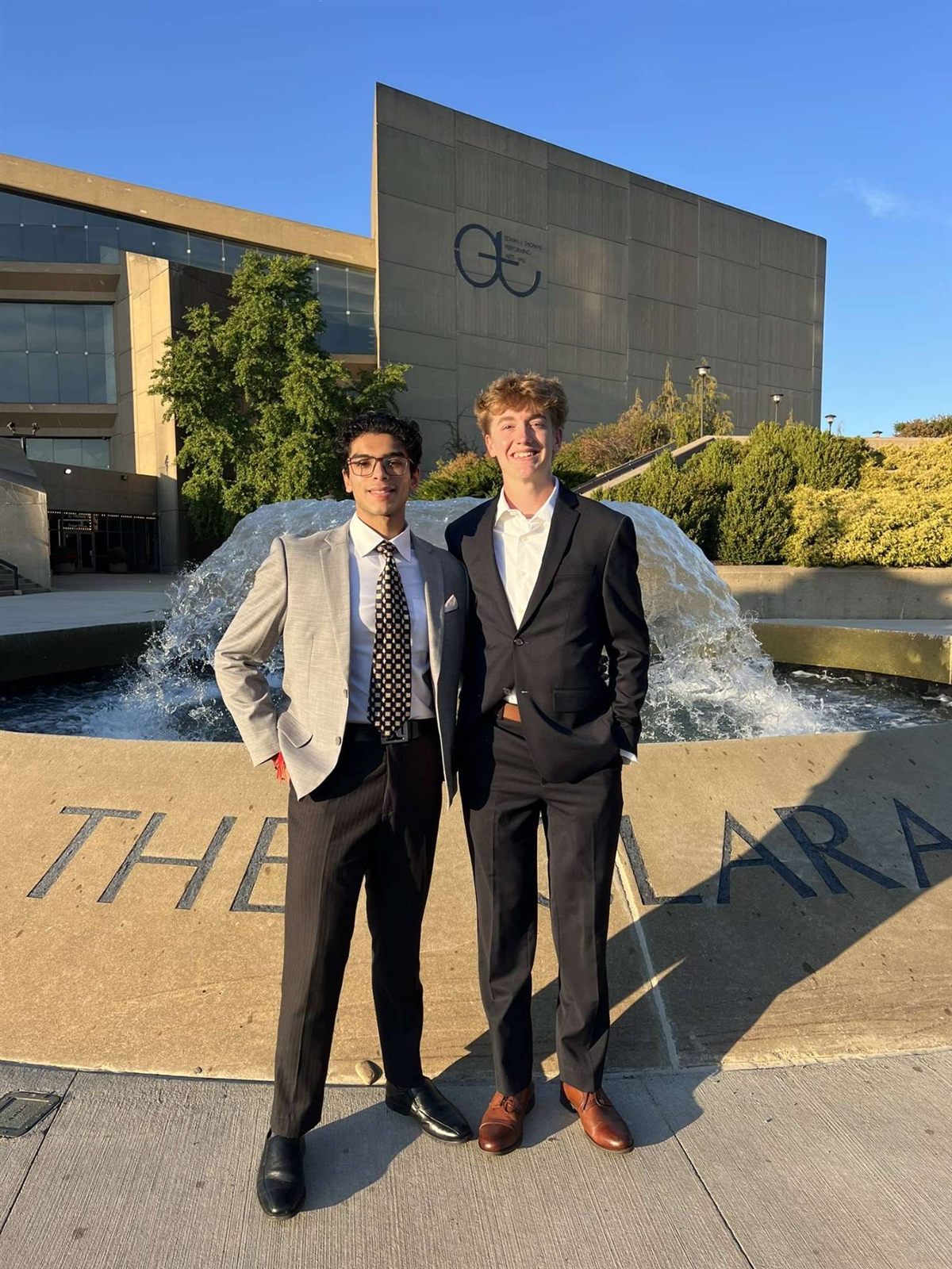Aaron in business attire with a friend at an evening event