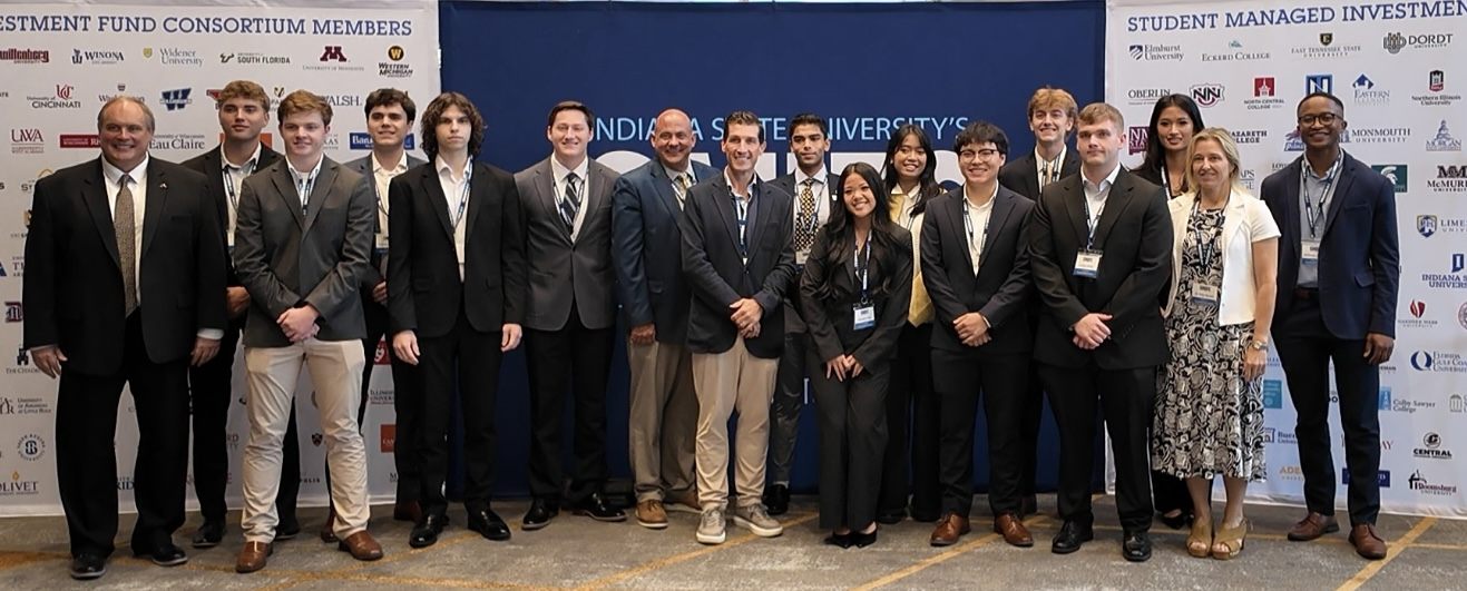 Akron students and faculty in front of the SMIFC consortium member banners